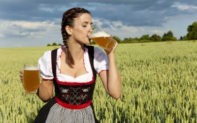 Девушка пьет пиво в поле