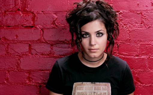 Katie Melua возле красной кирпичной стены