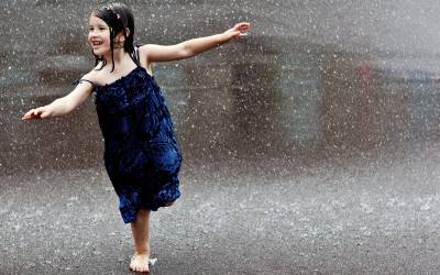 Ребенок бегает под дождем